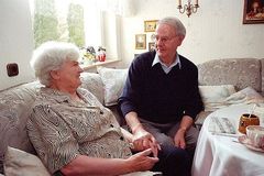 Älteres Rentner-Ehepaar im Wohnzimmer.