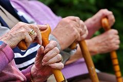 Senioren sitzen mit Gehstöcken auf einer Parkbank