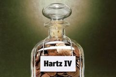 Glas mit Münzen und Hartz-IV-Aufschrift