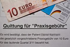Beleg über die Zahlung der Praxisgebühr liegt unter einem Zehn-Euro-Schein und einer Versichertenkarte