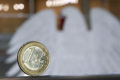 Ein-Euro-Münze steht auf einer Brüstung im Plenum