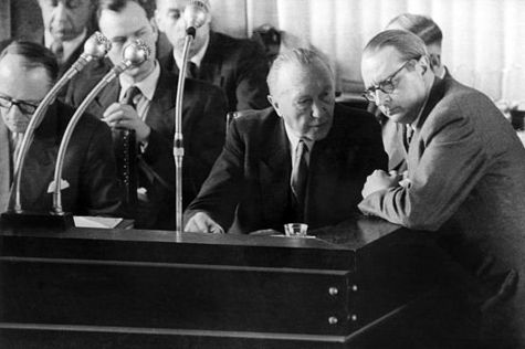 von Brentano am 19.03.1953 im Bonner Bundestag im Gespräch mit Bundeskanzler Konrad Adenauer am Rednerpult daneben Hallstein