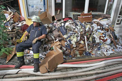 Ein Feuerwehrmann ruht sich sitzend auf einem Müllberg aus