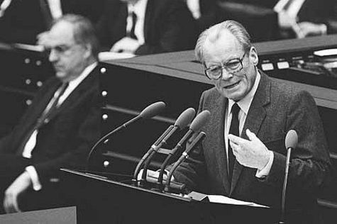 Der SPD-Parteivorsitzende Willy Brandt beteiligt sich an der Debatte über die von Bundeskanzler Helmut Kohl (links im Hintergrund) im Bundestag gestellte Vertrauensfrage.