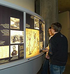 Jugendliche stehen vor Ausstellungsdisplay der historischen Ausstellung