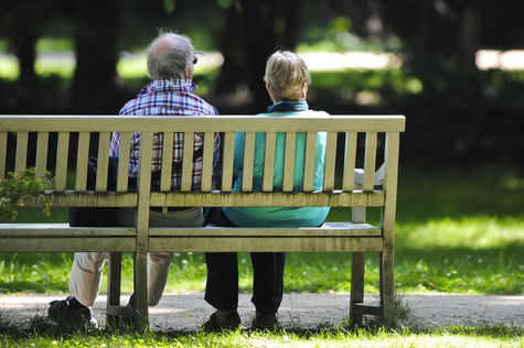 Zwei Rentner sitzen in Berlin auf einer Parkbank