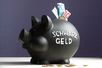 Euro-Scheine im Schlitz eines schwarzen Sparschweins mit der Aufschrift Schwarzgeld.