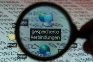 Im Schattenumriss einer Lupe schaut man auf eine Benutzeroberfläche eines Computers. Im Mittelpunkt der Lupe das Verzeichnis 