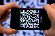 Ein Handy scannt einen QR-Code. - Video ansehen... - Öffnet neues Fenster
