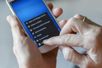 Hände halten ein Smartphone, Zeigefinger wischen