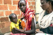 Symbolbild zentralafrikanische Republik. Zwei Frauen in bunten Kleidern und ein Kleinkind.