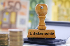 Stempel mit der Aufschrift Urheberrechte und Geld