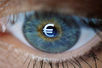 Ein menschliches Auge in Großaufnahme, auf der Pupille das Euro-Zeichen. 