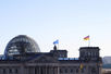 Kuppel des Reichstagsgebäudes mit Fahnen.