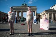 Zwei in Klarsichtfolie gehüllte Schauspielerinnen beim Straßentheater gegen Zwangsprostitution vor dem Brandenburger Tor in Berlin am 18. Oktober 2012