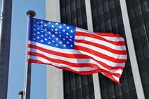 wehende USA-Fahne vor Bürohochhaus