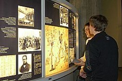 Jugendliche stehen vor Ausstellungsdisplay der historischen Ausstellung