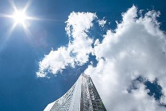 Sonne und Wolken über Gebäude