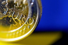 Euromünze und EU-Fahne