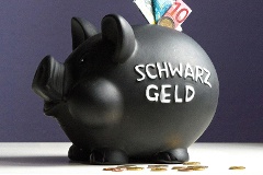 Euro-Scheine im Schlitz eines schwarzen Sparschweins mit der Aufschrift Schwarzgeld.