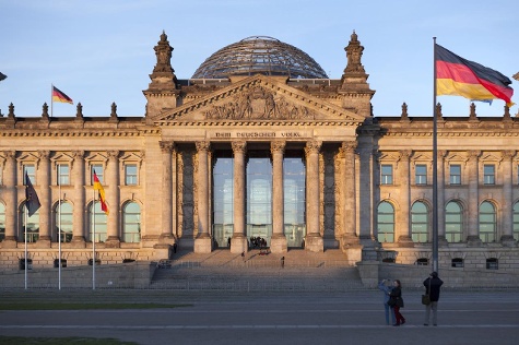 Blick vom Platz der Republik auf das Reichstagsgebäude bei Sonnenuntergang.