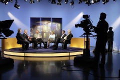 Foto: Abgeordnete und Moderator im Fernsehstudio des Deutschen Bundestages während einer Fernsehproduktion