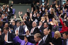 Abgeordnete stimmen mit Handzeichen ab.