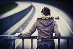 Frau steht auf Autobahnbrücke