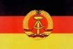Die schwarz-rot-goldene DDR-Fahne mit dem Emblem, das Hammer und Zirkel im Ährenkranz zeigt.