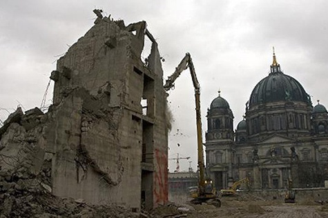 Mit einem Bagger werden am Montag (01.12.2008) in Berlin die letzten Reste des ehemaligen Palasts der Republik abgerissen. Rechts der Berliner Dom.