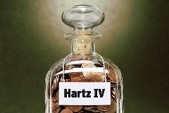 Glas mit Münzen und Hartz-IV-Aufschrift