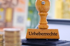 Stempel mit der Aufschrift Urheberrechte und Geld