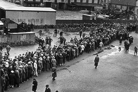 Arbeitslosenschlange vor dem Arbeitsamt Hannover: Nach Ausbruch der Weltwirtschaftskrise 1929 stieg die Arbeitslosigkeit stark an. Im Hintergrund ist die Parole »Wählt Hitler« zu erkennen. Foto: Walter Ballhause, um 1930