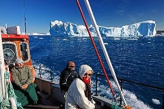 Urlauber an Deck eines Ausflugsbootes zwischen den Eisbergen bei Ilulissat, Diskobucht, Westküste, Grönland