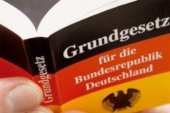 Symbolbild: Hand hält das Grundgesetz für die Bundesrepublik Deutschland