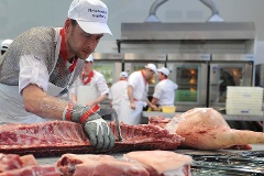 Metzger beim Ausloesen von Fleisch