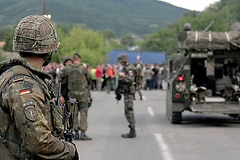 Ein deutscher Soldat (im Vordergrund) und gepanzerter Transportwagen