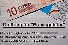 Beleg über die Zahlung der Praxisgebühr liegt unter einem Zehn-Euro-Schein und einer Versichertenkarte