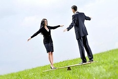 Frau und Mann balancieren auf einem Brett