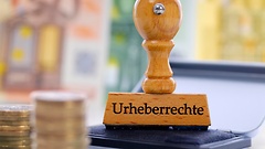 Stempel mit der Aufschrift Urheberrechte und Geld