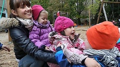 Mutter mit kleinen Kindern auf Spielplatz