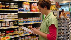 Angestellte kontrolliert Warenregale im Supermarkt