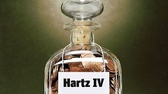 Glas mit Münzen und Hartz-IV-Aufschrift