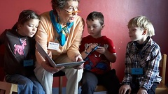 Lese-Oma liest zwei Kindern vor