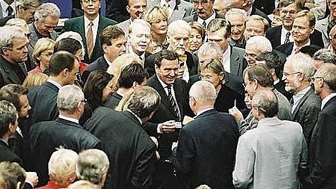 Bundeskanzler Gerhard Schröder (m) mit Stimmkärtchen bei der Abstimmung.
