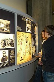 Jugendliche stehen vor Ausstellungsdisplay der historischen Ausstellung