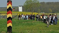 Schüler passieren einen ehemaligen Grenzpfahl