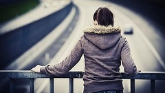 Frau steht auf Autobahnbrücke