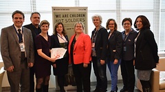 Susann Rüthrich (Dritte von links) bei der Übergabe der „roten Hände“ an Sharon Riggle (Fünfte von links), Büroleiterin von Leila Zerrogui