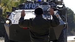 Soldat vor einem KFOR-Panzerwagen